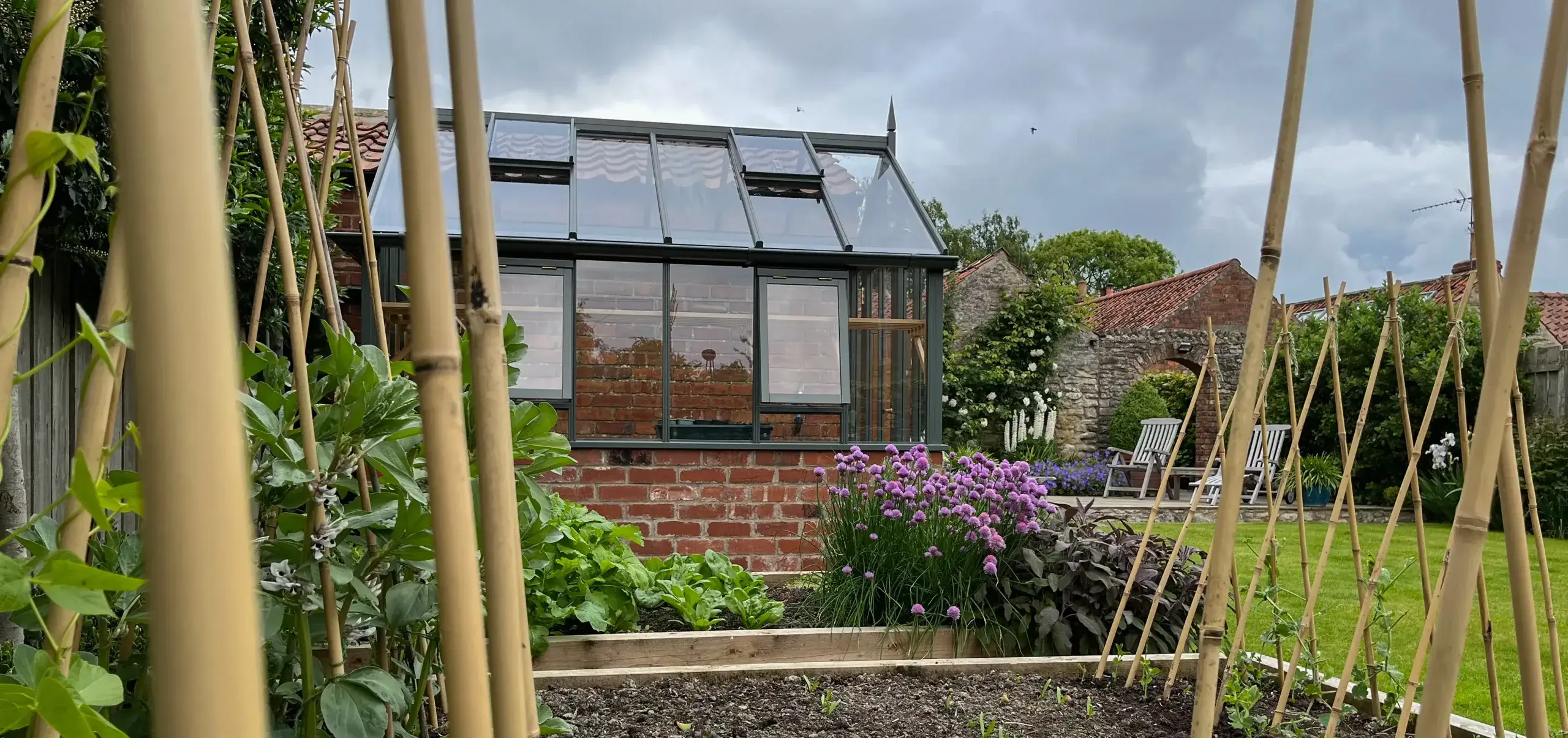 A greenhouse next to a vegetable garden