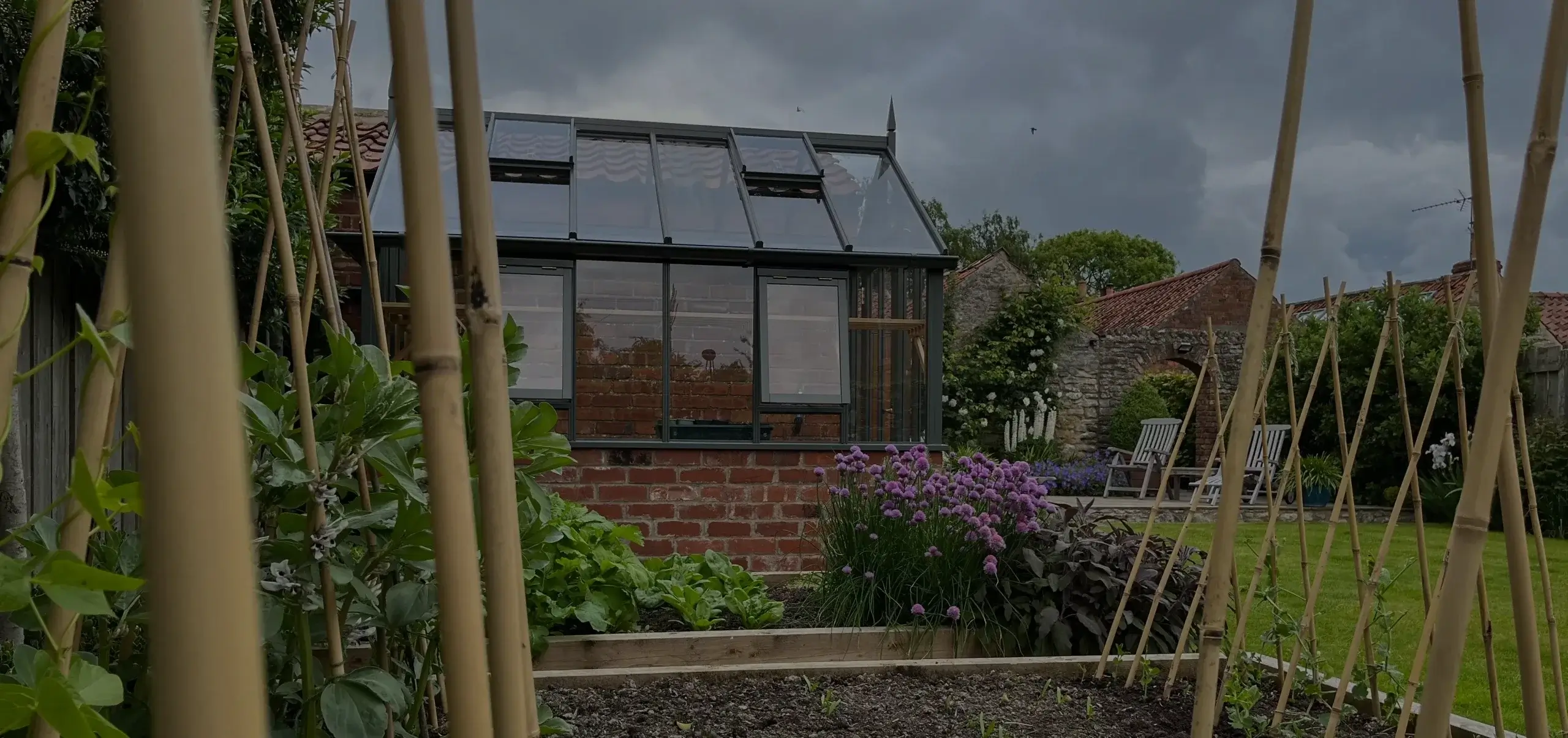 A greenhouse next to a vegetable garden